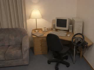 Tobias' Fahrerplatz mit Bürostuhl, Lenkrad und Röhrenmonitor.